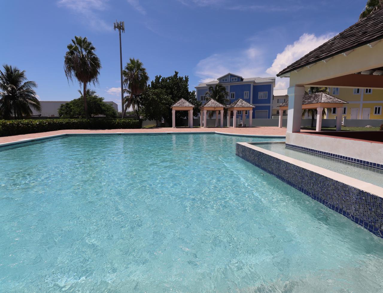Photograph of West Winds community pool, pastel homes and cabanas